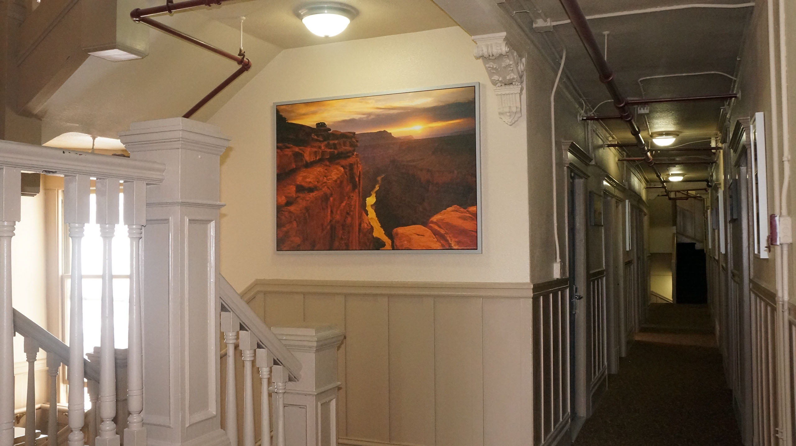 a hallway with a staircase and a picture on the wall